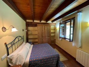 埃斯皮纳马Casa El Montero的一间带床的卧室,位于带窗户的房间内