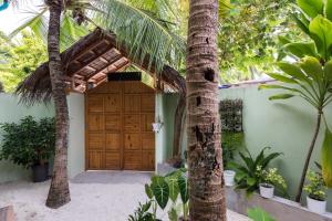 迪弗西Isla Dhiffushi的木车库门,两棵棕榈树