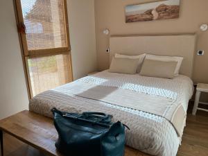 拉皮隆尼尔Maison « Embruns de mer » à 800 m de la mer的一间卧室配有一张大床,上面装有钱包