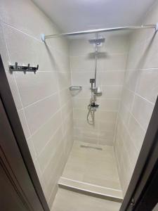 第比利斯HOSTEL NUMBER 49的浴室铺有白色瓷砖,设有淋浴间。