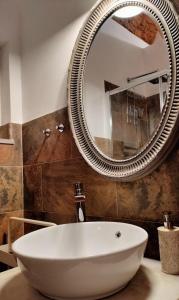 奥良Casa Victoria的一间带大镜子和盥洗盆的浴室