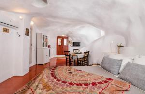 安坡里奥圣托里尼Traditional Farmers Caves的一间卧室配有一张床和一张桌子及椅子