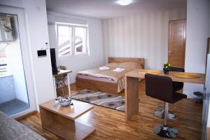 新帕扎尔Demir Apartmani的一间卧室配有一张床、一张桌子和一张桌子