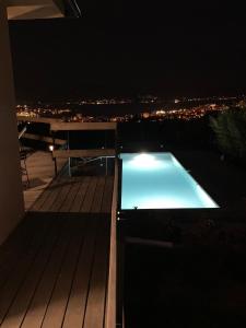 阿雅克修Villa de charme à Ajaccio的夜间屋顶的游泳池