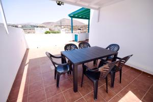 瓜蒂萨Villas Kalendra, Rofe, Lanzarote的阳台上配有一张黑色的桌子和椅子