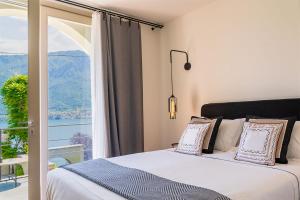 奥利维托拉里奥Villa Mojana Bellagio的一间卧室设有一张床和一个大窗户
