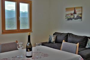 卡尔达罗Rebhof Kaltern的客厅配有一张桌子,并提供一瓶葡萄酒