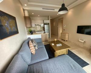 卡萨布兰卡Appartement confortable et ensoleillé, belle vue的客厅配有蓝色的沙发和桌子