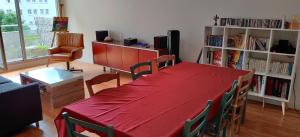 塞纳河畔伊夫里Chambre chez l'habitant a 5 minutes du métro的客厅配有红色的桌子和椅子