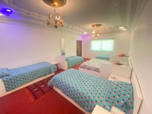 瓦迪穆萨Jordan Guest House的带三张床和镜子的客房