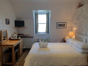 托伯莫里Harbour view的一间卧室配有一张床、一张书桌和一个窗户。