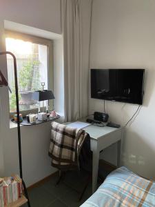 Suite privée avec accès jardin en coeur de village的一间卧室配有一张桌子、一台电视和一张床