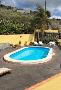 洛斯·亚诺斯·德·阿里丹Casa Agustín的一个带两把椅子的庭院内的游泳池