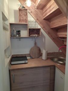 瑙吉伯尔热尼Keltike apartman的厨房配有带水槽的柜台和木制橱柜。