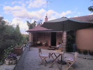 龙奇廖内roncio' cottage的庭院配有桌椅和遮阳伞。