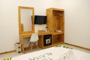 马富施Alaika Maafushi的客房设有一张带电视和镜子的书桌
