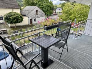 Ferienwohnung Brunnenblick的阳台上配有一张黑色的桌子和椅子