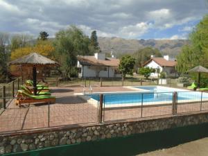 梅洛Aldea Blanca的房屋旁的游泳池配有椅子和遮阳伞