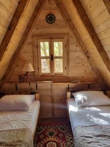 波德戈里察Wolf & Sheep Nature & Adventure的小木屋阁楼内的两张床