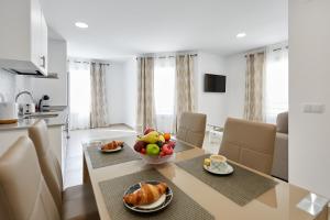 贝尼多姆Sonrisa Deluxe Apartments, Levante的厨房以及带一碗水果的桌子的用餐室。