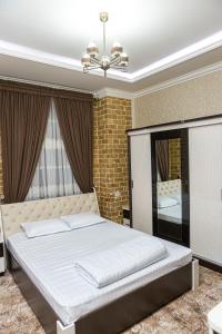 撒马尔罕AHMAD HOTEL的一间卧室配有一张大床和镜子