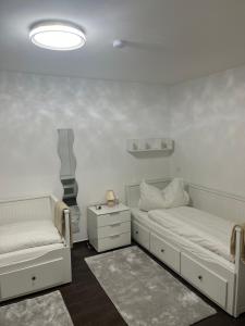 慕尼黑Bibis Ferienwohnung的一间白色卧室,配有两张床和 夜 ⁇ 