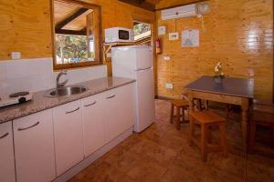 马贝拉Complejo Turístico & Camping Cabopino的厨房配有水槽、冰箱和桌子