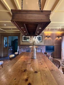 大哈林贝利The GateHouse at Stansted的大型用餐室配有大型木桌和椅子