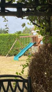 大哈林贝利The GateHouse at Stansted的庭院里一个带蓝色滑梯的游乐场