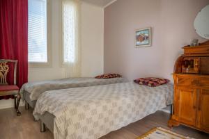 罗瓦涅米Villa Puistola & sauna, near Santa's Village的一间卧室配有两张床和红色椅子