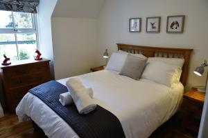 皮特洛赫里The Gardeners Cottage的一间卧室配有带白色床单和枕头的床。