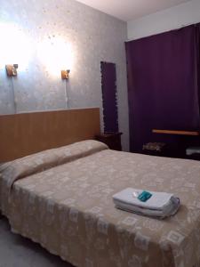 布宜诺斯艾利斯La Cascada Townhouse Hotel的一间卧室配有一张床,床上有毛巾