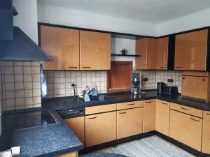 (H)Auszeit的厨房配有木制橱柜和炉灶烤箱。