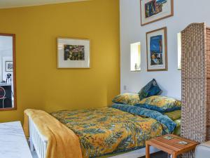 纽顿Secret Spot的一间卧室设有黄色的墙壁、一张床和一张桌子