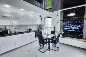 雷达Apartament 10 Glamour Aquapark Reda的厨房配有白色橱柜和桌椅