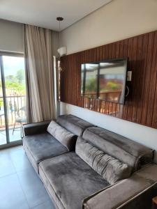 皮帕Flat Île de Pipa Resort - Centro的客厅配有沙发和墙上的电视