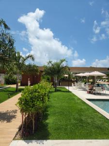 皮帕Flat Île de Pipa Resort - Centro的一个带游泳池和绿草的度假胜地
