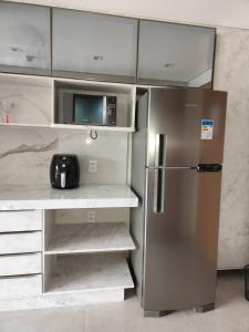 皮帕Flat Île de Pipa Resort - Centro的厨房配有不锈钢冰箱和微波炉。