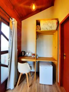 乌鲁比西Pousada Morada dos Sonhos的小房间配有一张桌子和一把椅子