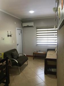 伊瓜苏港奥西奥公寓的带沙发和床的客厅以及窗户。
