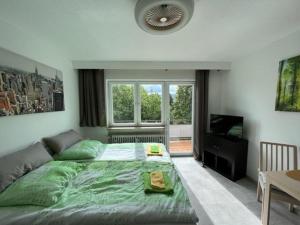 斯图加特Ruhiges und klimatisiertes Apartment的一间卧室配有一张绿色大床和电视。