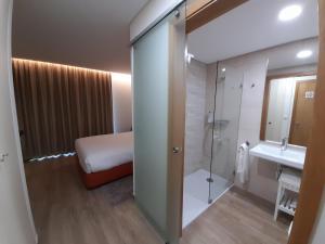 阿尔凡德加达菲Casas da Serra - Soeima Housing的配有床、淋浴和盥洗盆的浴室