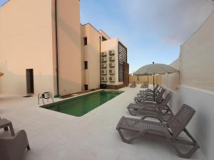 阿尔凡德加达菲Casas da Serra - Soeima Housing的一座带椅子和遮阳伞的游泳池