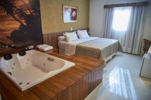 奥托兰迪亚商务公园酒店 的酒店客房配有一张床和浴缸。