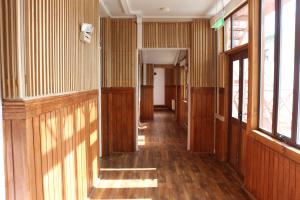 蓬塔阿雷纳斯Hostal Ochen的空的走廊,设有木镶板墙和窗户