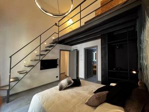巴勒莫Sant'Andrea - Luxury Rooms in Vucciria的一间卧室设有床铺、电视和楼梯。