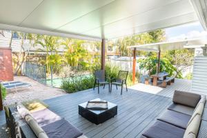 黄金海岸Hampton's House @ Southport - 3Bed Home+ Pool/BBQ的平台上设有带沙发和椅子的天井