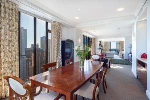 奥克兰Luxury Penthouse Apartment的一间带桌子和大窗户的用餐室