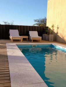 费德拉西翁Casa de Juan的一个带2张躺椅的游泳池,位于围栏旁