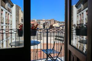 卡塔尼亚Dadà Suites的阳台配有桌椅,享有风景。